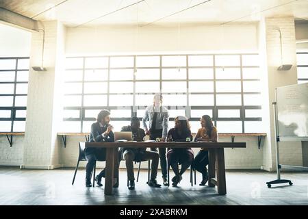 Designers, presentation or manager in startup for brainstorming, learning or teaching teamwork in meeting. Planning, laptop or mature boss talking in Stock Photo