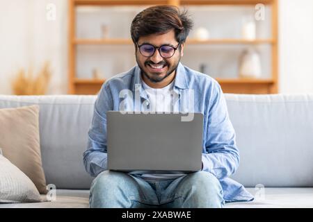 Man Sitting on a Couch Using a Laptop Stock Photo