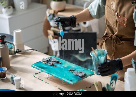 Epoxy Making Liquid cup with epoxy resin on scales. Process of making a craft resin ...