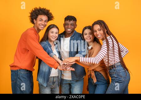 Diverse Group of Friends Stacking Hands Together in Studio Stock Photo
