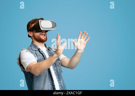 Happy young guy touching invisible subject in vr glasses Stock Photo