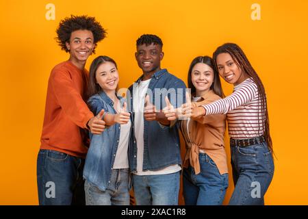 Diverse Group of Young Adults Give Thumbs Up in Studio Stock Photo