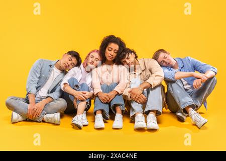 Five Friends Taking A Nap Together On A Yellow Background Stock Photo