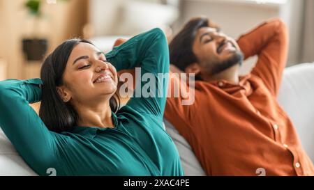 A Man and a Woman Laying on a Couch Stock Photo