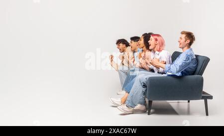 Diverse Group of Friends Cheer Excitedly While Sitting on Couch Stock Photo