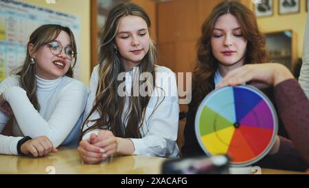 Students in physics class spin Newton's multicolored disk. Stock Photo