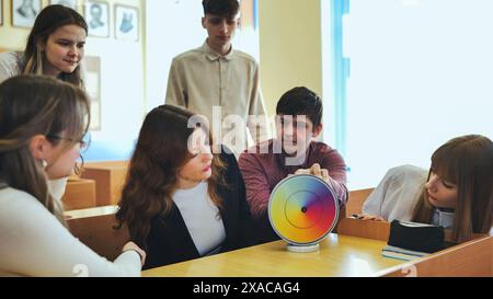 Students in physics class spin Newton's colorful wheel. Stock Photo