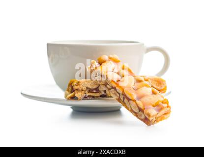 Close Up of almond Brittle Bars With Caramelized Coating and coffee cup isolated on a white background. Stock Photo