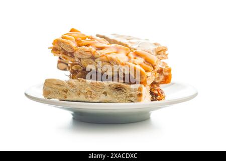 Close Up of almond Brittle Bars With Caramelized Coating and coffee cup isolated on a white background. Stock Photo