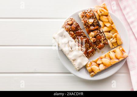 Close Up of almond Brittle Bars With Caramelized Coating on plate on a white table. Top view. Stock Photo