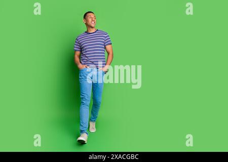 Photo of good looking nice man wear striped stylish clothes empty space isolated on green color background Stock Photo