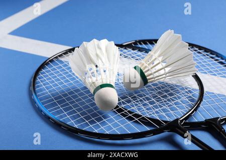 Feather badminton shuttlecocks and rackets on blue background, closeup Stock Photo