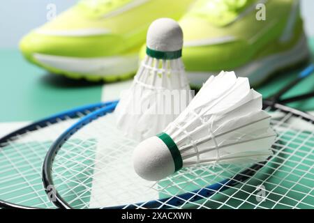 Feather badminton shuttlecocks and rackets on court, closeup Stock Photo