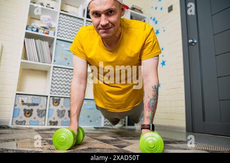 Man Doing Push Ups With Dumbbells At Home Stock Photo