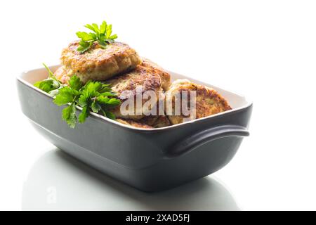 fried meat cutlets in a ceramic form on a wooden table . Stock Photo