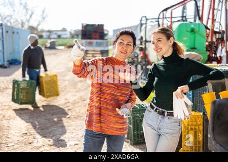 Positive women farmers discussing current issues in farm backyard Stock Photo