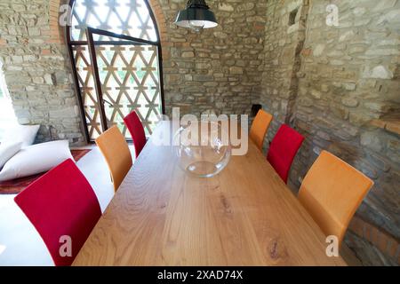 large wooden table with colored chairs in a rustic loft Stock Photo
