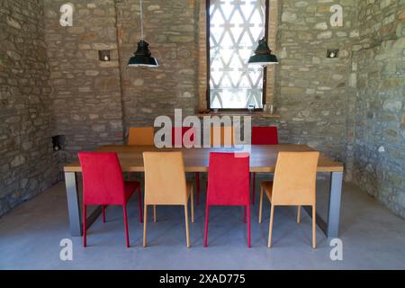 table with colored chairs in a rustic loft Stock Photo