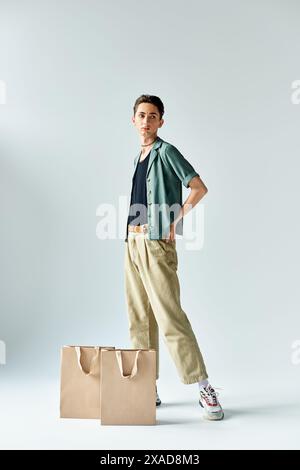 A young queer man confidently poses in a stylish black suit in a studio ...