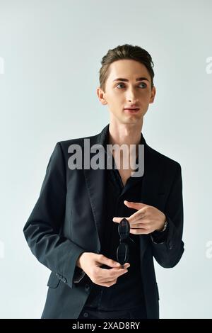A stylish young queer man strikes a pose while wearing a snake skin ...