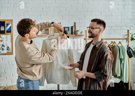 Two men stand next to a mannequin in a designer atelier Stock Photo