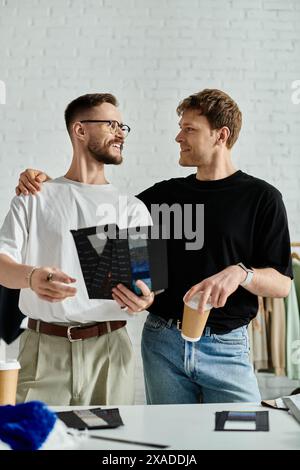 Two men collaborate on designing trendy attire in their atelier Stock Photo