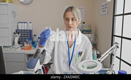 Focused young woman scientist analyzing a specimen in a modern laboratory setting Stock Photo