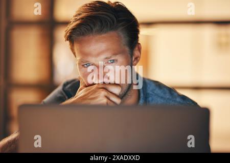 Office, thinking and laptop for man, night and research for deadline, web designer and creative in dark. Computer, employee and online for project Stock Photo