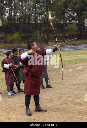 Bhutanese man aims arrow in archery competition, Chang Gewog, Thimphu, Bhutan Stock Photo