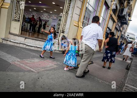 Street scen in the city centre - father and two girls in identical dresses, San Salvador, El Salvador Stock Photo