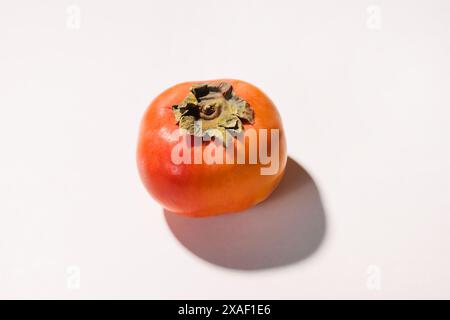 Ripe fresh persimmon isolated on white background in harsh light Stock Photo