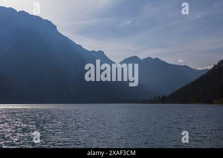 panoramic photo of Julian Alps mountains above Predil lake in Italy on sunny autumn day Stock Photo