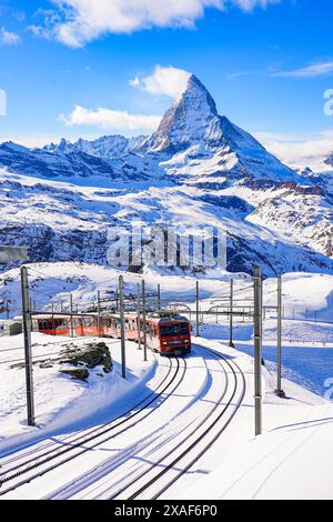 Cogwheel train of the Gornergrat Railway climbing the mountain facing the Matterhorn above Zermatt in the Swiss Alps in winter, Canton of Valais, Swit Stock Photo