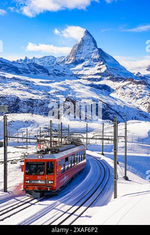 Cogwheel train of the Gornergrat Railway climbing the mountain facing the Matterhorn above Zermatt in the Swiss Alps in winter, Canton of Valais, Swit Stock Photo