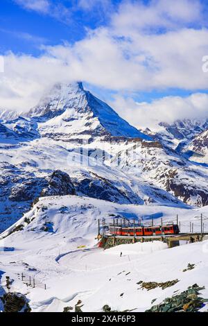 Cogwheel train of the Gornergrat Railway climbing the mountain facing the Matterhorn above Zermatt in the Swiss Alps in winter, Canton of Valais, Swit Stock Photo