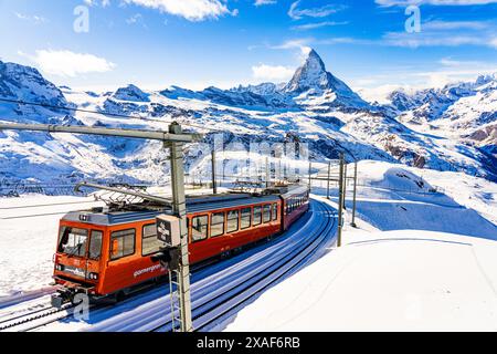 Cogwheel train of the Gornergrat Railway climbing the mountain facing the Matterhorn above Zermatt in the Swiss Alps in winter, Canton of Valais, Swit Stock Photo