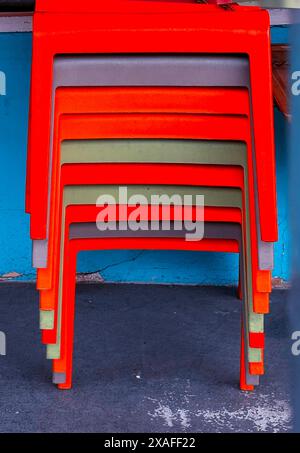 Brightly colored stacked plastic chairs Stock Photo