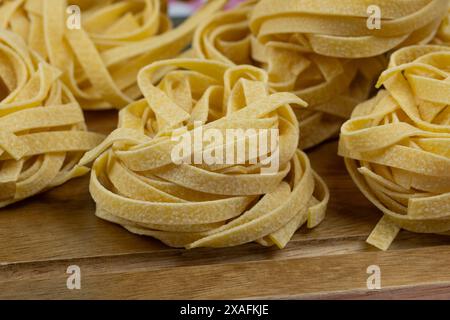 raw tagliatelle pasta on a cutting board Stock Photo