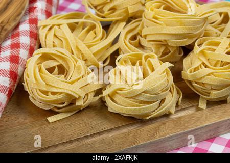raw tagliatelle pasta on a cutting board Stock Photo
