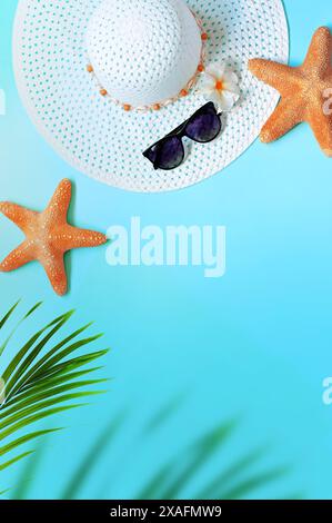 Summer background design concept. Top view with starfish, hat, sunglasses and palm leaves on blue background. Stock Photo