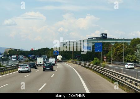 Barcelona, Spain - May 24, 2023: Along the highway there is an industrial building of the OS company. Cars are moving along the highway. Stock Photo