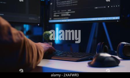 Focus on computer peripheral used by IT admin to type lines of code on desktop PC in apartment. Close up shot of keyboard used by software engineer programming at home, camera B Stock Photo