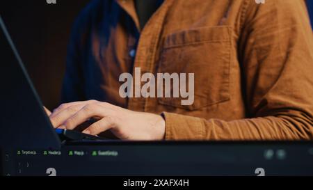 Programmer concentrating on writing complex binary code scripts on laptop terminal, close up shot. Teleworking IT specialist standing in home office, using programming to safeguard consumer data Stock Photo