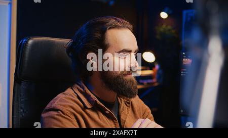 Happy software engineer feeling satisfied after removing all bugs while coding on computer, close up. Joyous IT admin looking at PC screen, pleased after solving script errors, camera B close up Stock Photo