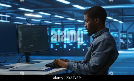 Software developer programming in high tech facility with server rows providing computing resources for different workloads. IT expert supervising data center supercomputers Stock Photo