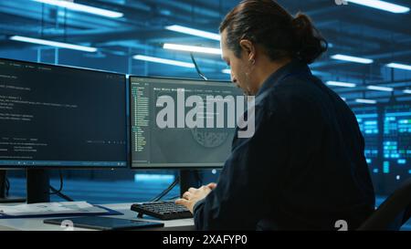 System admin focused on programming in server room housing advanced equipment storing massive datasets. Developer typing code on PC to mend data center racks doing complex computational operations Stock Photo