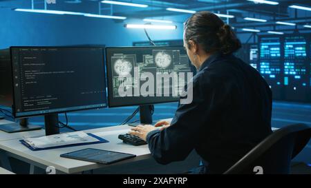System administrator in server room frightened by sensitive data threatened by hacking attack on computers. Afraid man jumping out of desk chair, rushing to save data center from unauthorized access Stock Photo