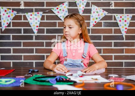 Cute preschooler girl makes art at a summer outdoor party Stock Photo