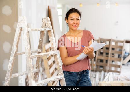 Portrait of positive woman construction manager with documents Stock Photo