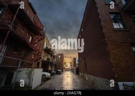 Picture of a street of Le Plateau, in Montreal, in a residential, poor area of the city of Quebec, under the rain. This image captures a dilapidated r Stock Photo